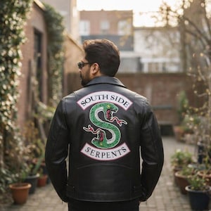 May include: Black leather jacket with a South Side Serpents patch on the back. The patch features a green snake with red accents and the words "South Side Serpents" in a pink banner.
