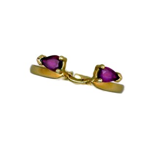 May include: A gold ring with two pear-shaped purple gemstones.