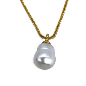 May include: A gold chain necklace with a large, white baroque pearl pendant.