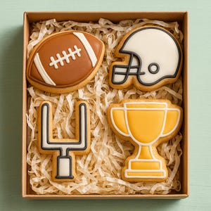 Peut inclure: Une boîte de biscuits sur le thème du football américain. Les biscuits comprennent un ballon de football marron, un casque blanc, un trophée jaune et un but. Les biscuits sont décorés de glaçage blanc et noir et reposent sur du papier déchiqueté.