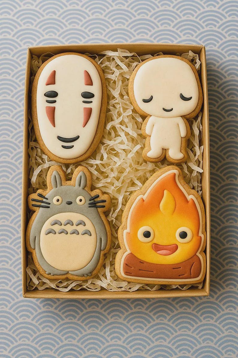 Puede incluir: Una caja con cuatro galletas decoradas con personajes de Studio Ghibli. Las galletas incluyen a Sin Rostro, un Kodama, Totoro y Calcifer. Est&aacute;n decoradas con glaseado y descansan sobre papel triturado.
