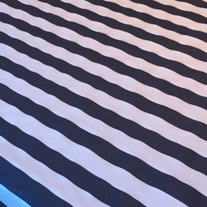 May include: A black and white striped fabric with a diagonal pattern. The fabric has a slight sheen and a smooth texture.