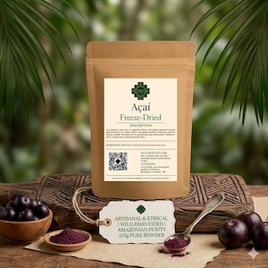 May include: A brown pouch of freeze-dried Açaí powder with a white label featuring text, a QR code, and nutritional details. A small tag reads 125g pure powder. A wooden bowl of fresh Açaí berries, a small dish of purple powder, and a metal spoon are present.
