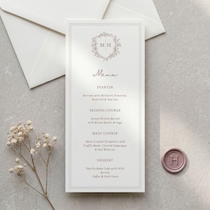 May include: A vertical white menu card featuring a floral crest with the letters M H, the word Menu, and four courses listed: Starter, Second Course, Main Course, and Dessert. The card has a thin border and is printed in dark gray ink.