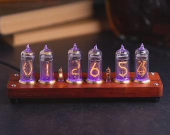 May include: A nixie tube clock featuring six glass tubes with glowing orange numerals and purple base lighting, mounted on a rectangular dark wood base with metallic accents and small screws at the corners, displaying the numbers 0, 1, 2, 6, 5, and 4.