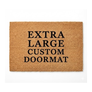 May include: A rectangular, extra-large custom doormat made of a natural fiber material. The doormat has a light brown color and features the words "EXTRA LARGE CUSTOM DOORMAT" in bold, black capital letters.