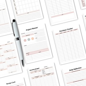 May include: A collection of white planner pages with various layouts, including "Yearly Overview," "Weekly Budget," and "Project Planner." A silver and white pen rests on the pages. The pages have a soft pink accent color.