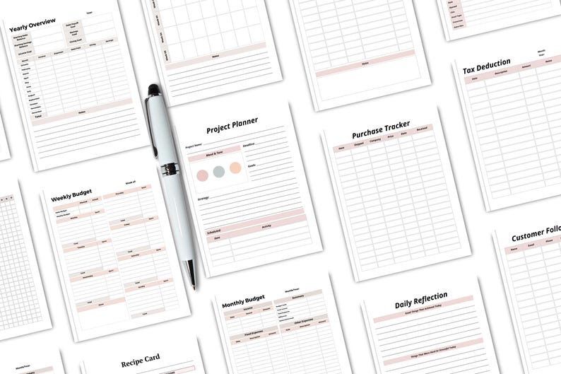 May include: A collection of white planner pages with various layouts, including "Yearly Overview," "Weekly Budget," and "Project Planner." A silver and white pen rests on the pages. The pages have a soft pink accent color.