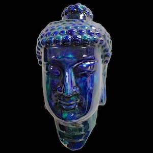 May include: A blue and green glazed ceramic Buddha head sculpture. The sculpture has a serene expression and is detailed with a textured bun.