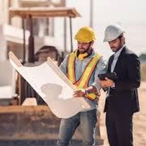 May include: Two men at a construction site examining blueprints. One wears a yellow hard hat and safety vest, holding the plans. The other wears a white hard hat and a suit, holding a tablet. A bulldozer is visible in the background.