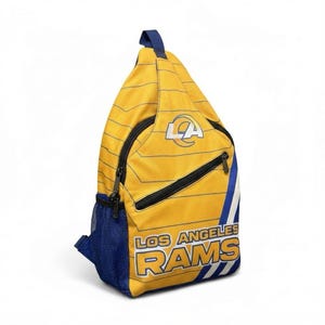 Puede incluir: Mochila bandolera amarilla y azul con el logotipo y el texto de Los Angeles Rams. La bolsa presenta un patrón de rayas, una cremallera negra y un bolsillo de malla azul. El logotipo de LA está en la esquina superior derecha.