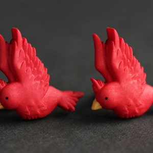 Puede incluir: Un par de pendientes de p&aacute;jaro cardenal rojo. Los p&aacute;jaros est&aacute;n en vuelo con las alas extendidas. Los pendientes est&aacute;n hechos de arcilla polim&eacute;rica y tienen un aspecto realista.