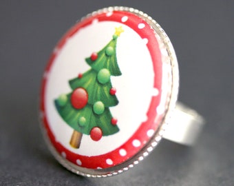 May include: A silver ring with a red and white polka dot background and a green Christmas tree with red baubles.