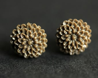 May include: A pair of brown flower-shaped stud earrings. The earrings are made of a textured material and have a 3D design.