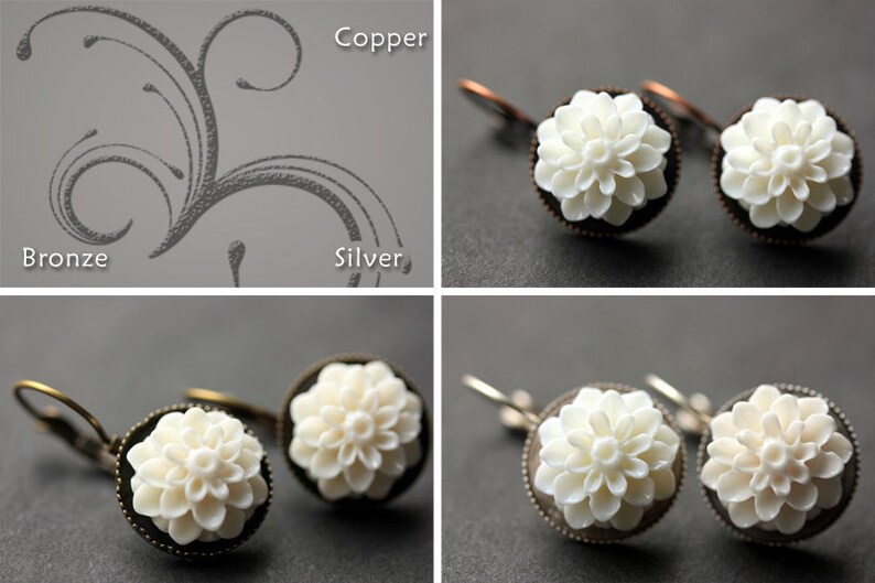 May include: Two pairs of earrings with white flower-shaped charms. The earrings are on a gray background. The top pair has copper hooks and the bottom pair has bronze hooks.