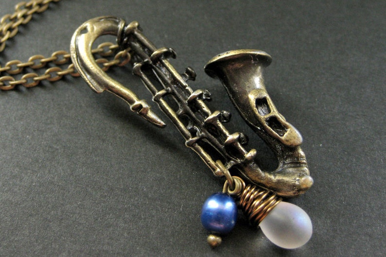 Saxophone Necklace. Musical Instrument Necklace with Frosted Teardrop and Blue Pearl. Handmade Jewellery. image 1