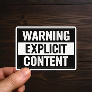 May include: A rectangular sticker with the words "WARNING EXPLICIT CONTENT" in bold white letters on a black and white background. The sticker is held by a hand against a dark wood grain background.