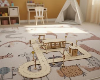 Puede incluir: Un juego de carretera de juguete de madera con edificios y señales de tráfico se muestra sobre una alfombra estampada. El juego incluye una carretera, una parada de autobús y otras estructuras. La alfombra tiene un diseño caprichoso con ilustraciones de animales.