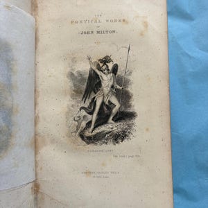 May include: An open book with aged, yellowed pages. The title page reads "THE POETICAL WORKS OF JOHN MILTON." An illustration depicts a winged figure with a spear. The text "PARADISE LOST" is below the illustration. Published by Charles Wells, New York.