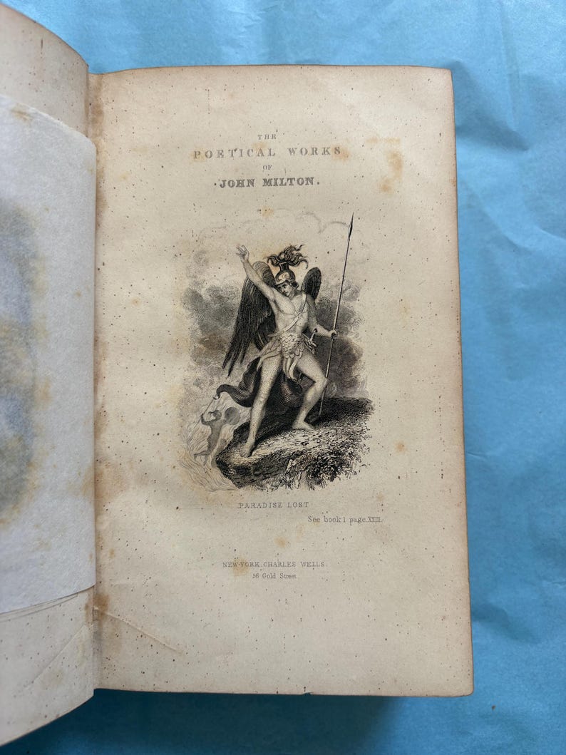 May include: An open book with aged, yellowed pages. The title page reads "THE POETICAL WORKS OF JOHN MILTON." An illustration depicts a winged figure with a spear. The text "PARADISE LOST" is below the illustration. Published by Charles Wells, New York.