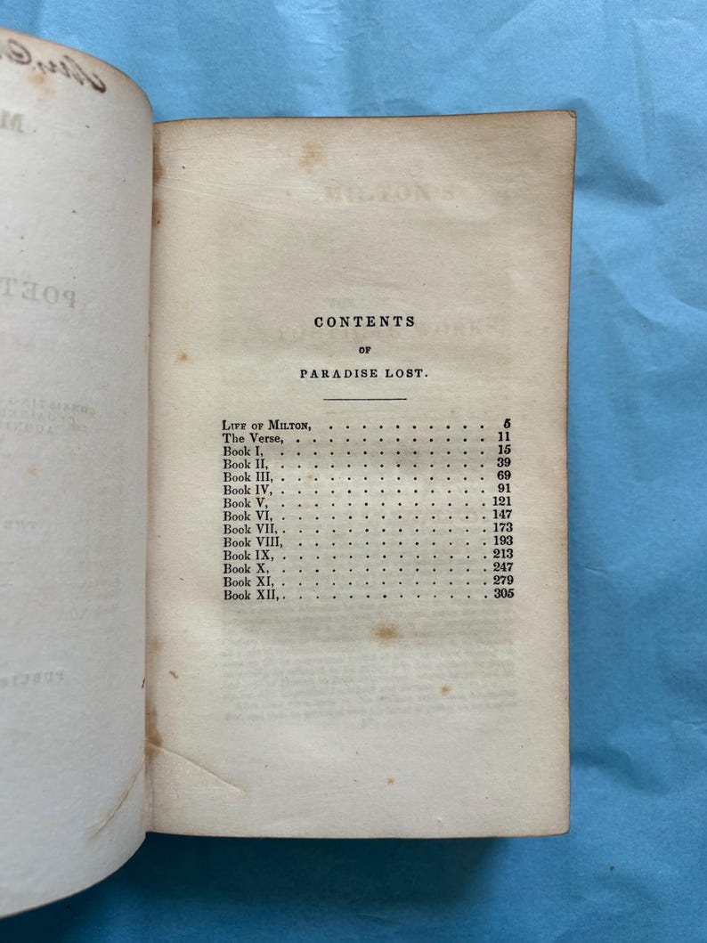 May include: Open book with the contents page of "Paradise Lost" visible. The page is aged with visible wear and tear. The text includes "CONTENTS OF PARADISE LOST" and a list of book titles and page numbers.