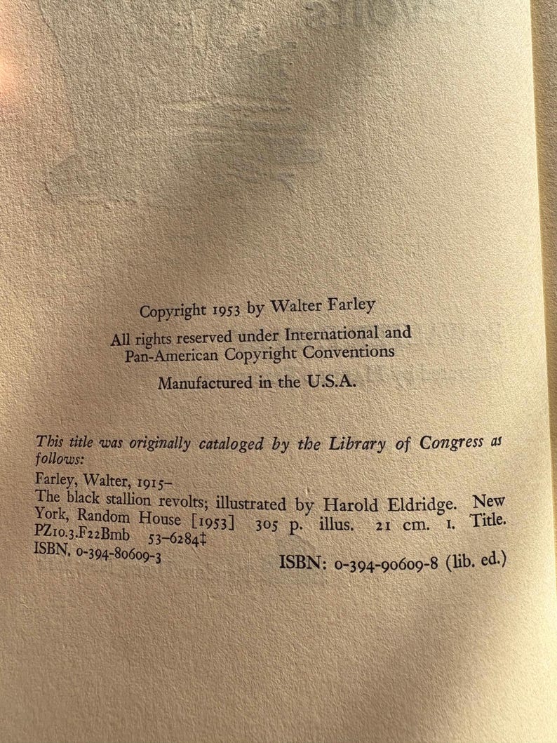 Op de afbeelding: Een open boekpagina met tekst uit "The black stallion revolts" van Walter Farley. De tekst bevat copyrightinformatie, catalogusgegevens van de Library of Congress en ISBN-nummers. Het boek is vervaardigd in de U.S.A.