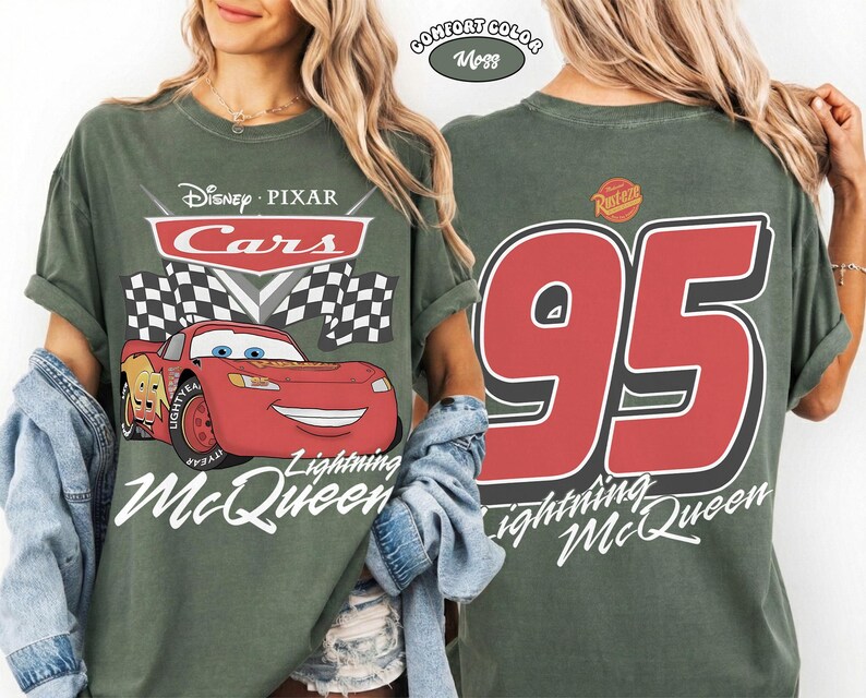May include: A moss green t-shirt featuring a front graphic of the red Lightning McQueen character from Disney Pixar Cars with checkered flags and text. The back of the shirt displays a large red number 95 with the Rust-eze logo above it.