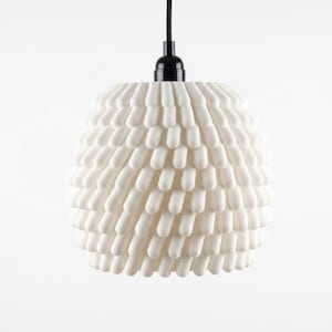 May include: A white pendant light fixture featuring a textured, spherical shade covered in numerous small, rounded, finger-like protrusions. The shade is suspended from a black cord and a black socket, creating a stark contrast against the white.