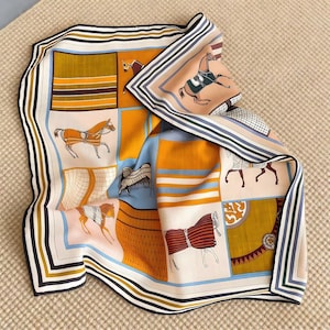 Może przedstawiać: Kwadratowy jedwabny szal z motywem koni. Szal ma wzór patchwork z różnymi ilustracjami koni w odcieniach pomarańczu, błękitu i beżu. Obramowanie jest w paski w kolorach czarnym, białym i granatowym.