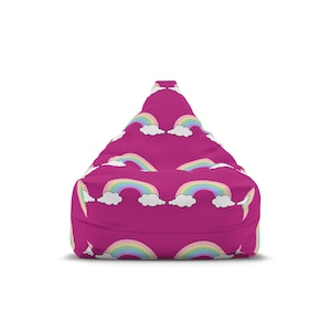 以下が含まれることがあります： マゼンタ色のビーズクッション。虹と白い雲の繰り返し模様。虹はパステルカラーで、雲はふわふわ。ビーズクッションは涙の形をしています。