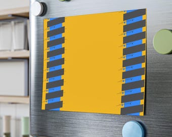 Op de afbeelding: Een rechthoekige magneet met een gele kern en verticale grijze en blauwe strepen aan elke kant. De magneet is bevestigd aan een roestvrijstalen koelkastdeur met kleurrijke ronde magneten.