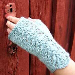 May include: A light blue knitted fingerless glove with a chevron pattern.
