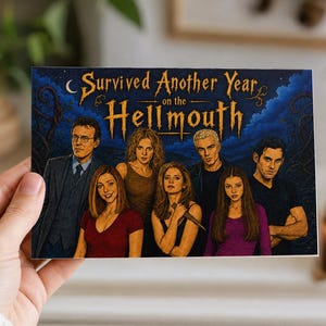 May include: A rectangular greeting card featuring a stylised illustration of seven characters from Buffy the Vampire Slayer. The text at the top reads, "Survived Another Year on the HELLMOUTH" in a golden, gothic-inspired font against a dark blue background.