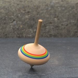 May include: A wooden spinning top with a rainbow colored band around the middle.