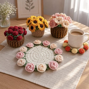 May include: A collection of crochet items including three small potted flower arrangements in red, yellow, and pink, a large circular white coaster with pink and cream rose accents, and a smaller circular coaster with orange and yellow flower details.