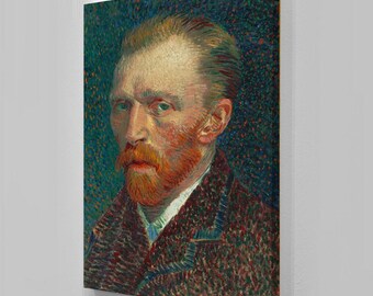 May include: A framed print of a self-portrait by Vincent van Gogh. The painting features a man with a red beard and hair, wearing a dark jacket and a white collared shirt. The background is a dark blue with small brushstrokes.