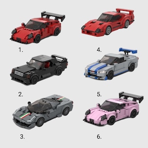 May include: Six toy race cars in various colors: red, black, gray, and pink. Each car is constructed from interlocking blocks, featuring spoilers and detailed designs. The cars are numbered 1 through 6.