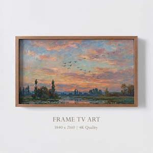 以下が含まれることがあります： 水面上の夕焼けを描いた額入りの風景画。空はオレンジ、ピンク、青の色合いで満たされています。鳥が飛んでいます。フレームは木製です。下部のテキストは「FRAME TV ART」と書かれています。