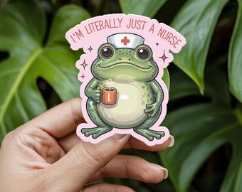 May include: A sticker featuring a cartoon frog wearing a nurse's cap and holding a mug. The frog is green and white with large eyes. The sticker has the text "I'M LITERALLY JUST A NURSE" in pink.
