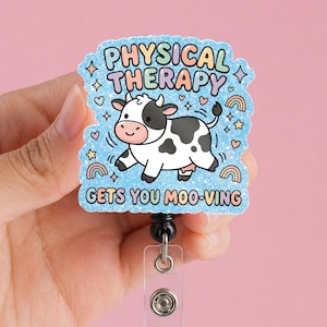 May include: A light blue badge reel with the words "PHYSICAL THERAPY" and "GETS YOU MOO-VING" in colorful text. The badge reel features a cartoon cow with black spots and a smiling face, surrounded by hearts, stars, and rainbows.
