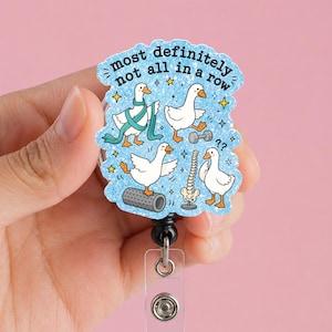 May include: A blue glittery badge reel featuring four white geese in various poses with physical therapy equipment including a foam roller, a dumbbell, and a spine model. The text reads, most definitely not all in a row, surrounded by yellow stars.
