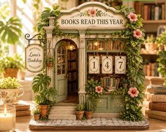 May include: A miniature bookstore model titled Luna's Bookshop with a sign reading BOOKS READ THIS YEAR. The structure features a green facade, an open door, and three hanging signs displaying the numbers 1, 4, and 7, adorned with green vines and pink flowers.