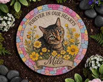 May include: A round memorial stone featuring a brown tabby cat illustration surrounded by yellow flowers. The text reads FOREVER IN OUR HEARTS and the name Milo on a banner. The border consists of a colorful mosaic pattern of small tiles.