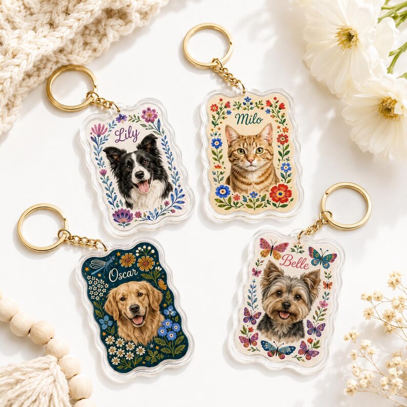May include: Four rectangular acrylic keychains with gold-tone rings. Each features a pet portrait surrounded by floral illustrations and a name: Lily with a border collie, Milo with a tabby cat, Oscar with a golden retriever, and Belle with a terrier.
