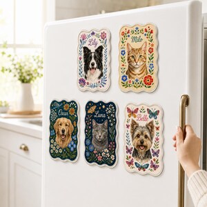 May include: Five rectangular magnets with scalloped edges attached to a white refrigerator. Each magnet features a portrait of a pet, including dogs and cats, surrounded by colorful floral and butterfly illustrations with the names Lily, Milo, Oscar, Luna, and Belle.