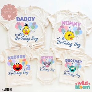 May include: A collection of beige t-shirts and a onesie with Sesame Street character graphics. The shirts read "Daddy," "Mommy," "Archer," "Sister," and "Brother" with "of the Birthday Boy" text. Each shirt features a different character and balloons.