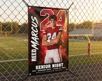May include: A rectangular vertical banner featuring a football player in a red jersey with the number 24, the name REED MARCUS, and the text SENIOR NIGHT, #24 RUNNING BACK, CLASS OF 2027, WESTFIELD WARRIORS FOOTBALL, displayed against a red smoke background.