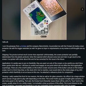 May include: A white and silver handheld gaming device with a screen displaying a colorful game, resting on a keyboard. The device is open, showcasing the screen protector. The image is a review of a screen protector.