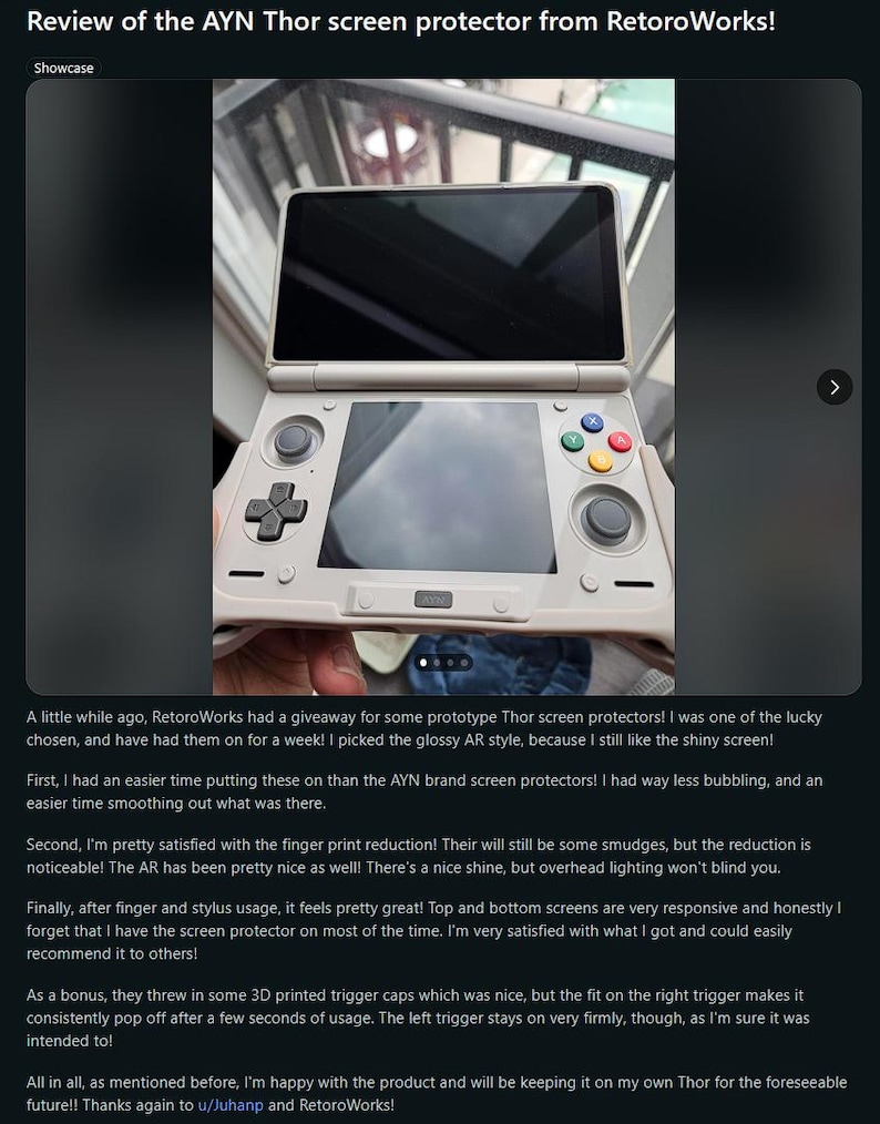 May include: A handheld gaming console with a screen protector applied. The console is white with black and colored buttons. The screen displays a dark image. The text "Review of the AYN Thor screen protector from RetoroWorks!" is at the top.