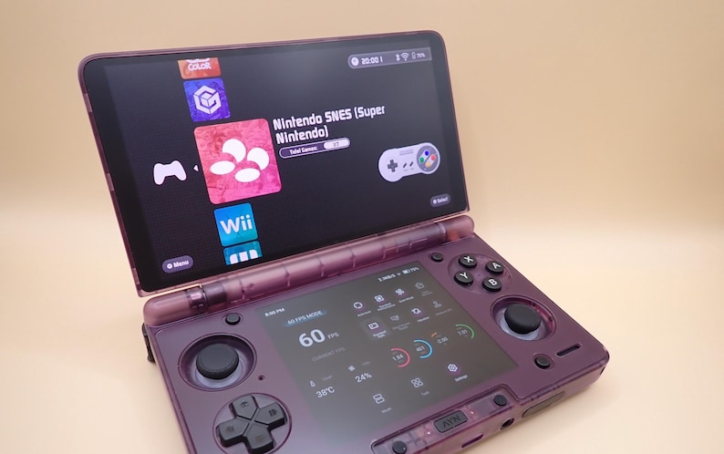 May include: A purple handheld gaming device with two screens. The top screen displays game icons, including "Nintendo SNES (Super Nintendo)". The bottom screen shows performance metrics. The device has buttons and a joystick for gameplay.